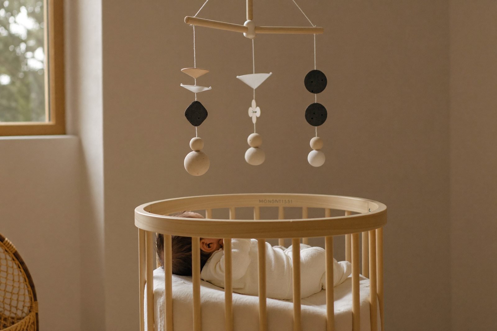 Mobile de Munari en carton noir et blanc suspendu au-dessus d'un tapis d'éveil