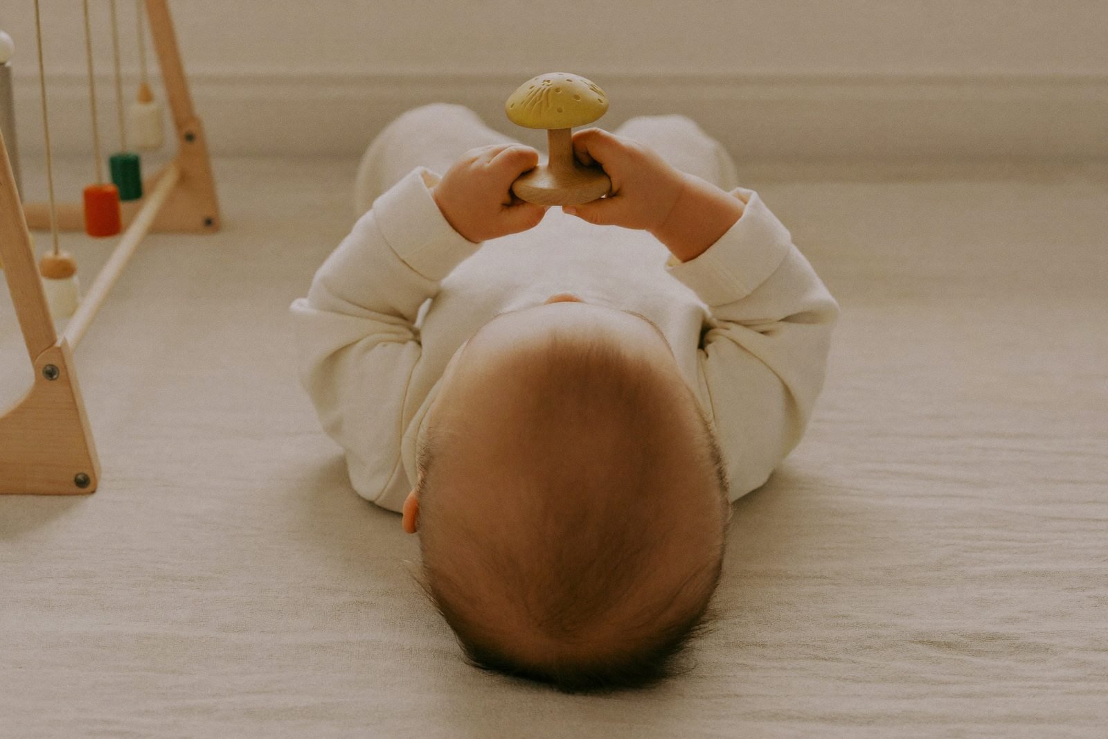 Bébé de six mois assis devant un panier d'objets en bois et en osier
