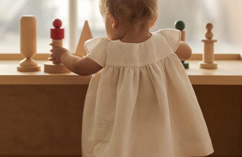 Panier de jouets rangés dans un placard, à côté d'une étagère volontairement dégarnie