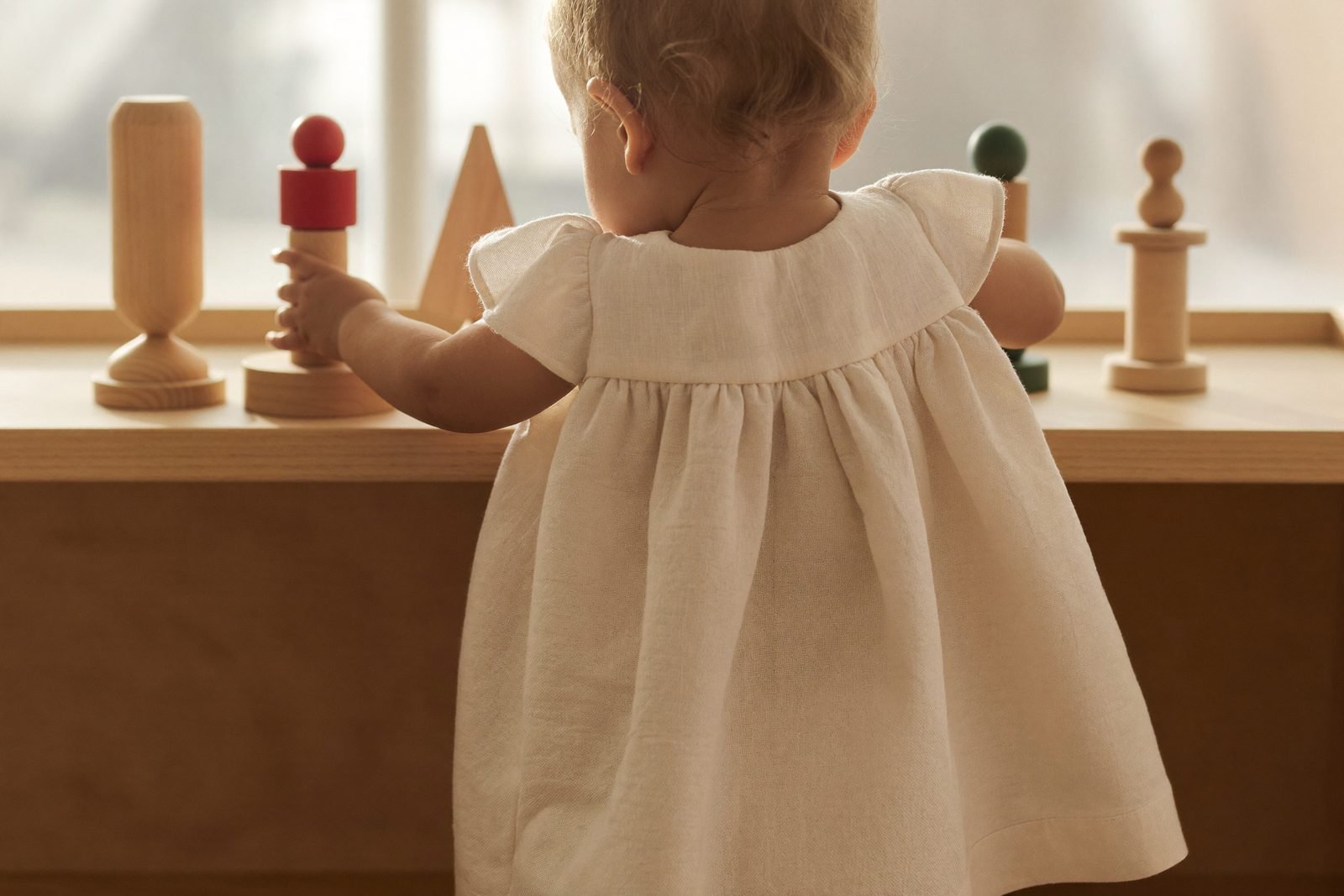 Panier de jouets rangés dans un placard, à côté d'une étagère volontairement dégarnie