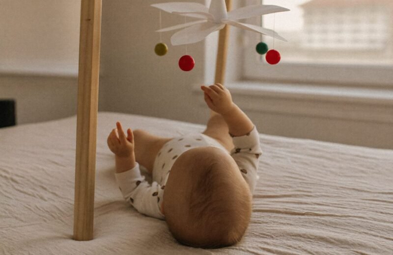Trois mobiles Montessori suspendus côte à côte, du noir et blanc aux sphères colorées