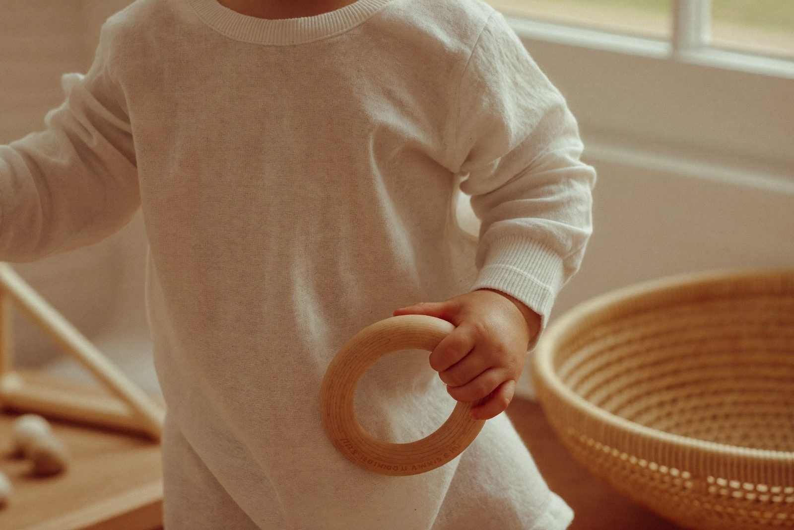 Bébé allongé sur le dos portant un anneau de bois à la bouche