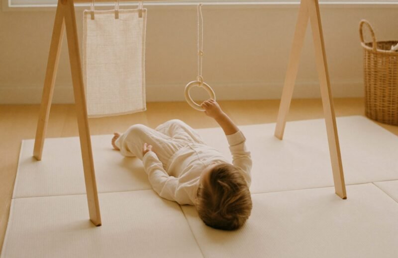Bébé de trois mois allongé sous un mobile aux formes géométriques suspendues