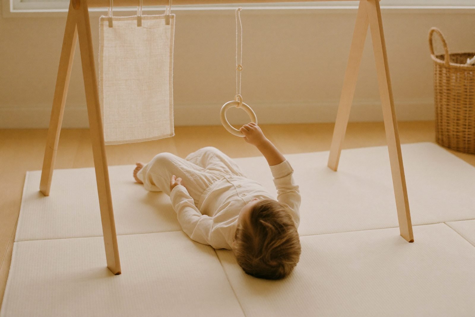 Bébé de trois mois allongé sous un mobile aux formes géométriques suspendues