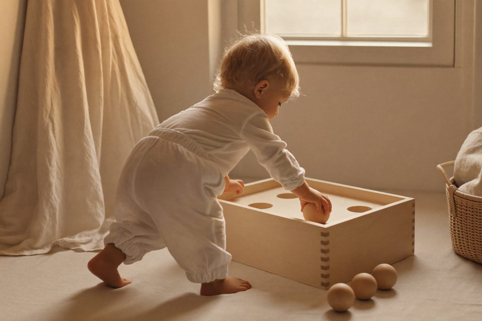 Boîte à formes en bois avec un cube et un cylindre posés devant