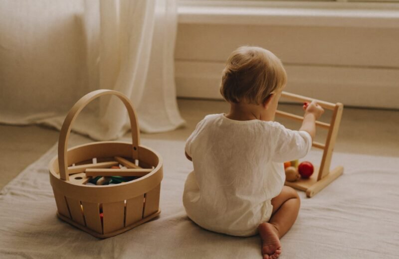 Enfant assis seul sur un tapis, absorbé par une activité de construction